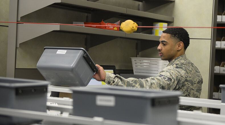 Airman 1st Class John Richardson, 88th Medical Group pharmacy technician, grabs a transport bucket off the conveyor belt for packaging, inside the new Kittyhawk Satellite Pharmacy Nov. 13 at Wright-Patterson Air Force Base. The new pharmacy is open for business after approximately 17 months of construction. (U.S. Air Force photo/Wesley Farnsworth)