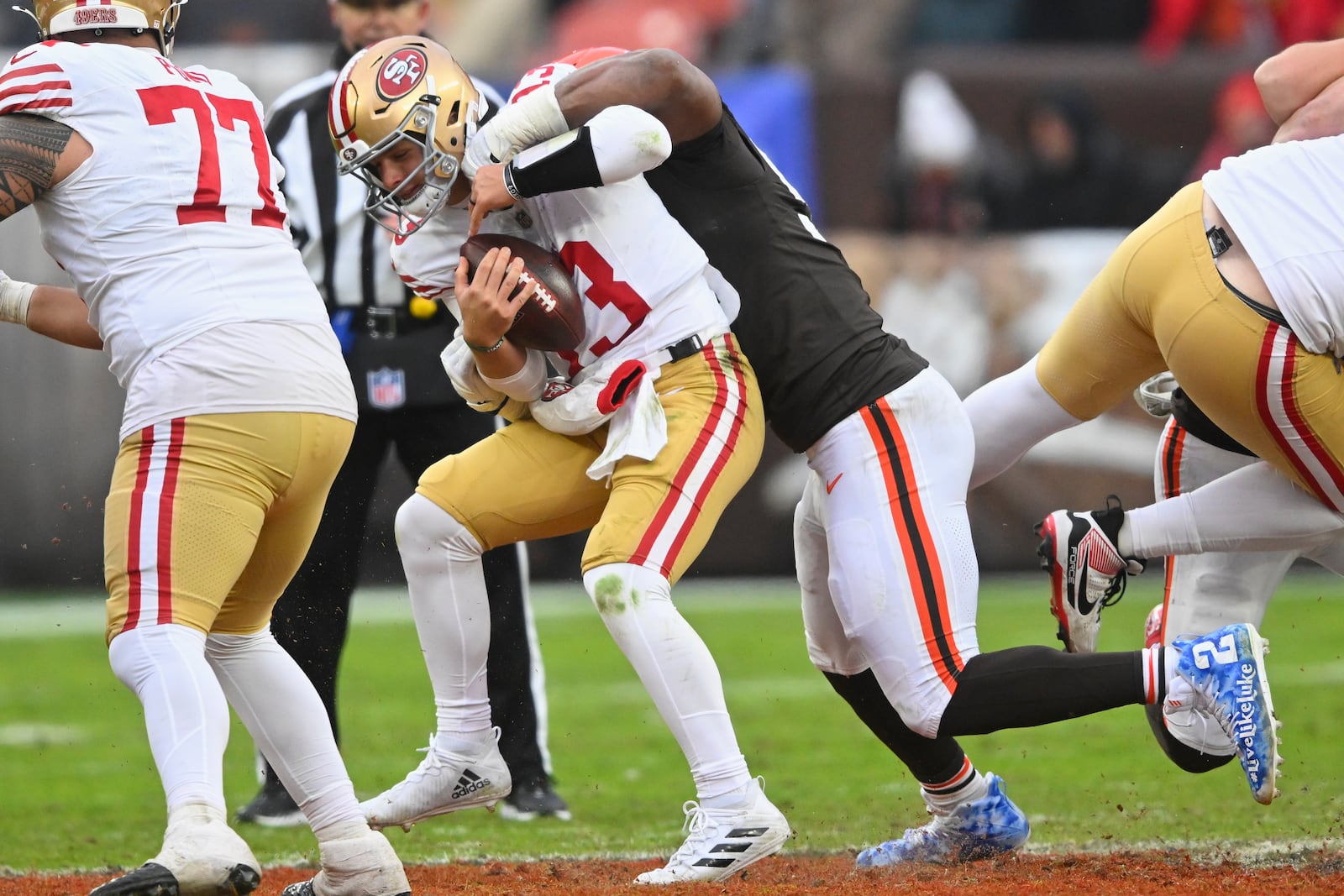 Cleveland Browns defensive end Myles Garrett, middle right, sacks San Francisco 49ers quarterback Brock Purdy during the second half of an NFL football game, Sunday, Nov. 30, 2025, in Cleveland. (AP Photo/David Richard)