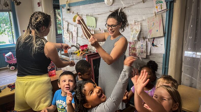 Rainbow Years Child Care Center teachers Abbie Beirise and Heather Simonds use bubbles to get the children to use their whole bodies before lunch Friday June 4, 2021. JIM NOELKER/STAFF