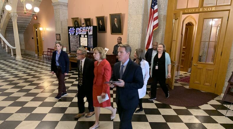 Gov. Mike DeWine on Wednesday walks to his daily press conference with his wife Fran.