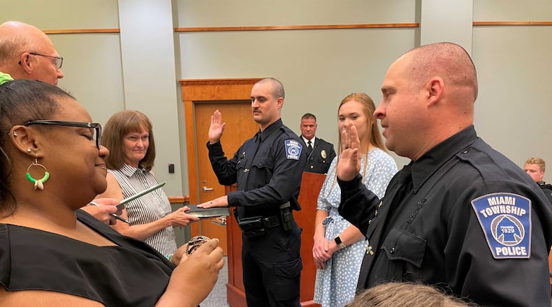 Miami Twp. Police Department staffing grew to 34 policer officers with the swearing in of two new officers Jason McIntosh (center) and Christopher Renkel (right) during a Miami Twp. Board of Trustees meeting Tuesday June 6, 2023. The two men were sworn in by Miami Twp. Fiscal Officer Greg Clingerman. CONTRIBUTED