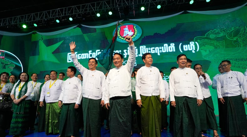 FILE - Khin Yi, center, chairman of the military-backed Union Solidarity and Development Party (USDP), cheers together with the party's members during a ceremony to release the party's election manifesto at Thuwunna indoor stadium Wednesday, Nov. 19, 2025, in Yangon, Myanmar. (AP Photo/Thein Zaw, File)