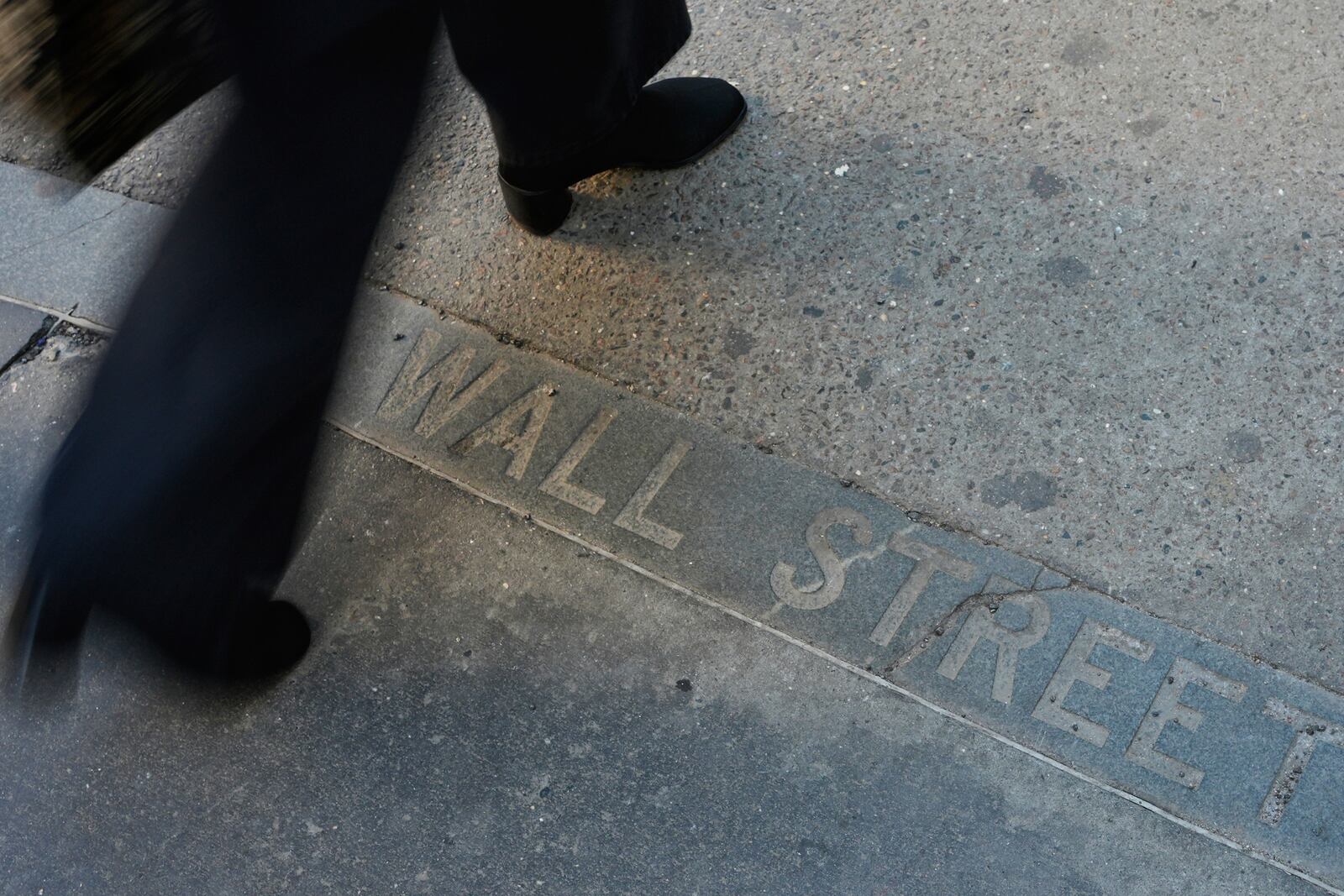 Pedestrians walk past a Wall Street sign on the sidewalk near the New York Stock Exchange in New York, Wednesday, April 9, 2025. (AP Photo/Seth Wenig)