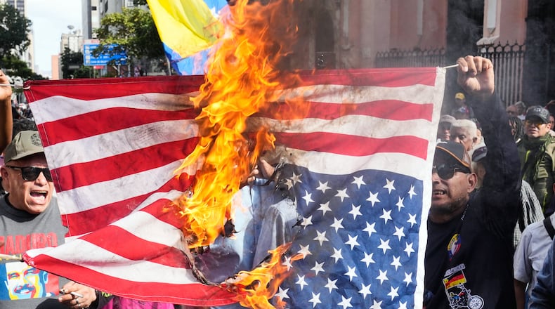 Government supporters burn a U.S. flag in Caracas, Venezuela, Saturday, Jan. 3, 2026, after U.S. President Donald Trump announced that U.S. forces had captured Venezuelan President Nicolás Maduro and his wife. (AP Photo/Ariana Cubillos)