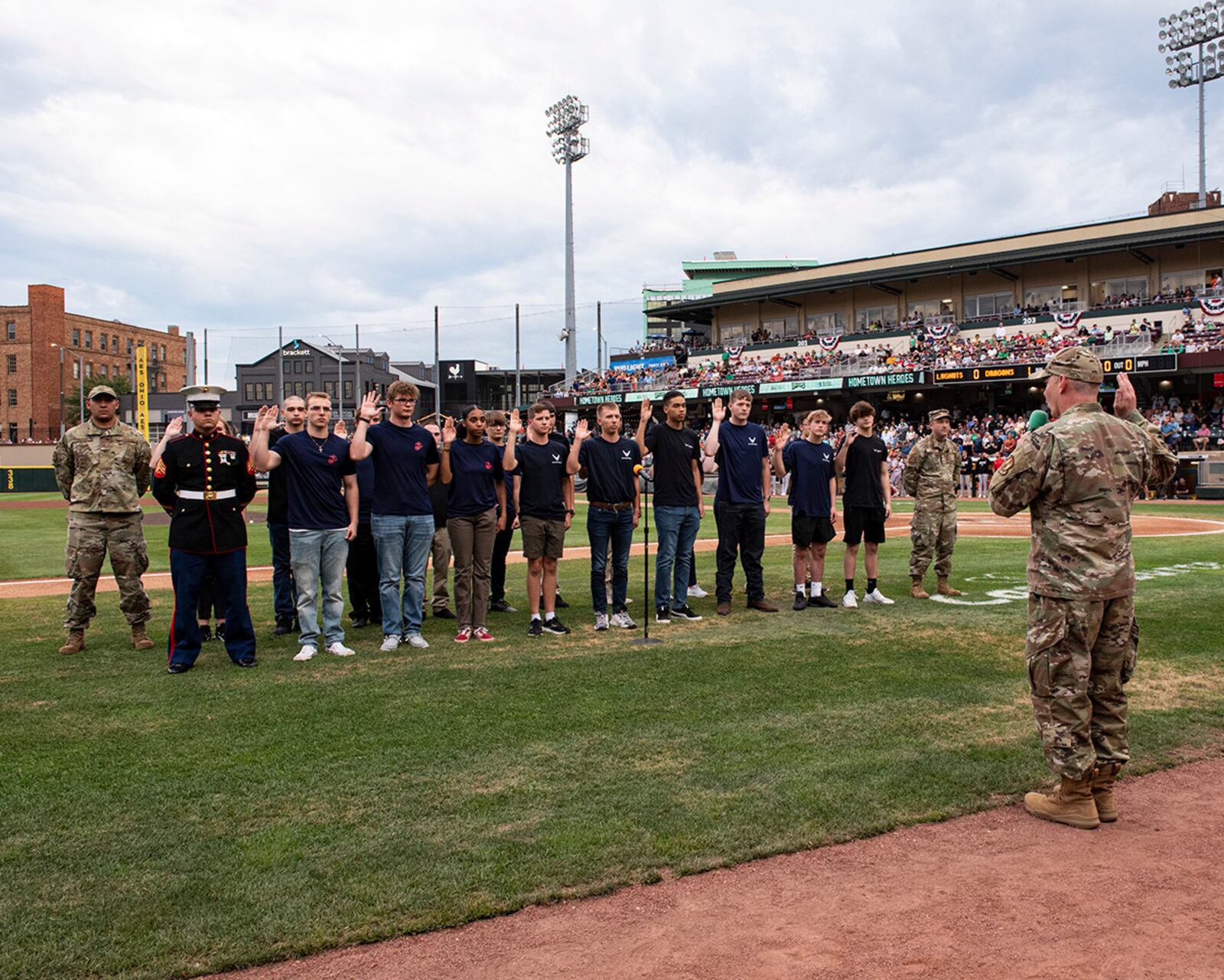 Col. Christopher Meeker, 88th Air Base Wing and Wright-Patterson Air Force Base commander, administers the oath of enlistment to a group of Air Force and Marine recruits in the Delayed Entry Program during a Dayton Dragons game Aug. 13 at Day Air Ballpark. U.S. AIR FORCE PHOTO/JAIMA FOGG