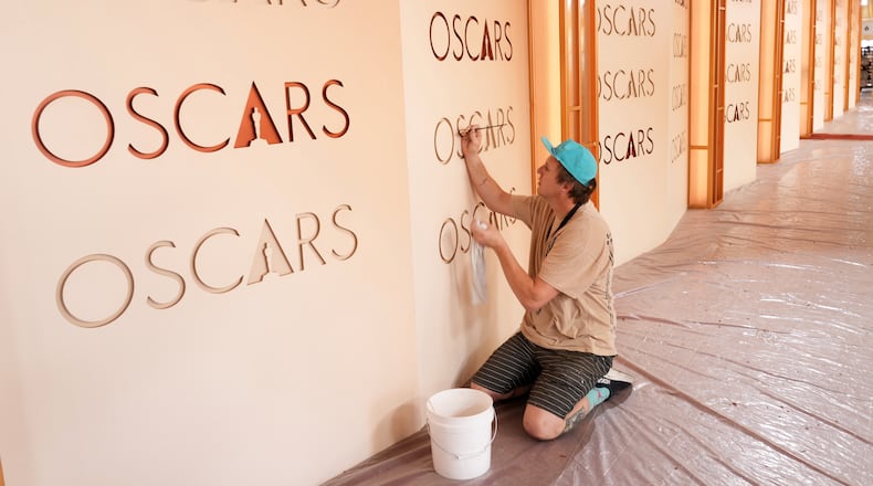Motion picture painter Chance Gugler, whose father was also a film set painter who worked on over 80 movies, touches up an Oscars backdrop on Friday, March 13, 2026, at the Dolby Theatre in Los Angeles, in preparation for Sunday's Academy Awards ceremony. (AP Photo/Chris Pizzello)