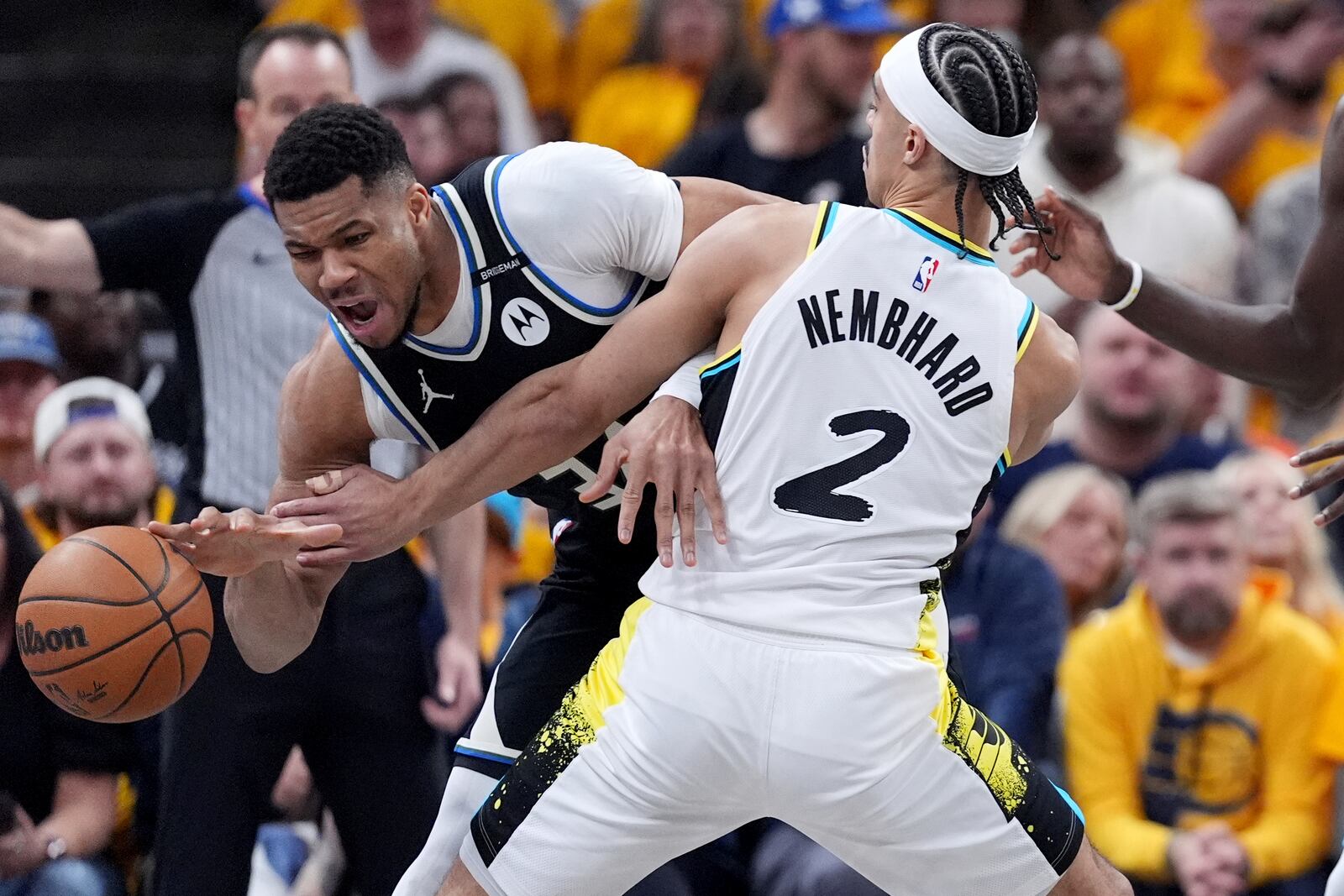 Milwaukee Bucks' Giannis Antetokounmpo, left, dribbles as Indiana Pacers' Andrew Nembhard (2) defends during the first half of a first-round NBA basketball playoff game, Saturday, April 19, 2025, in Indianapolis. (AP Photo/Michael Conroy)