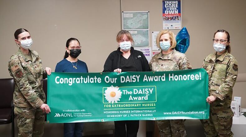 From left: Capt. Lindsay Postrado, Women’s Health Clinic; Maria Bautista, intensive care unit; Col. Erin Knightner, interim chief nurse; and 1st Lt. Jasmine Cairns, Medical Surgical Unit, present Theresa Franz (center) with the DAISY Award during a surprise ceremony Feb. 12 at Wright-Patterson Medical Center. Franz is a nurse with the Orthopedic/Neurosurgical Clinic. CONTRIBUTED PHOTO