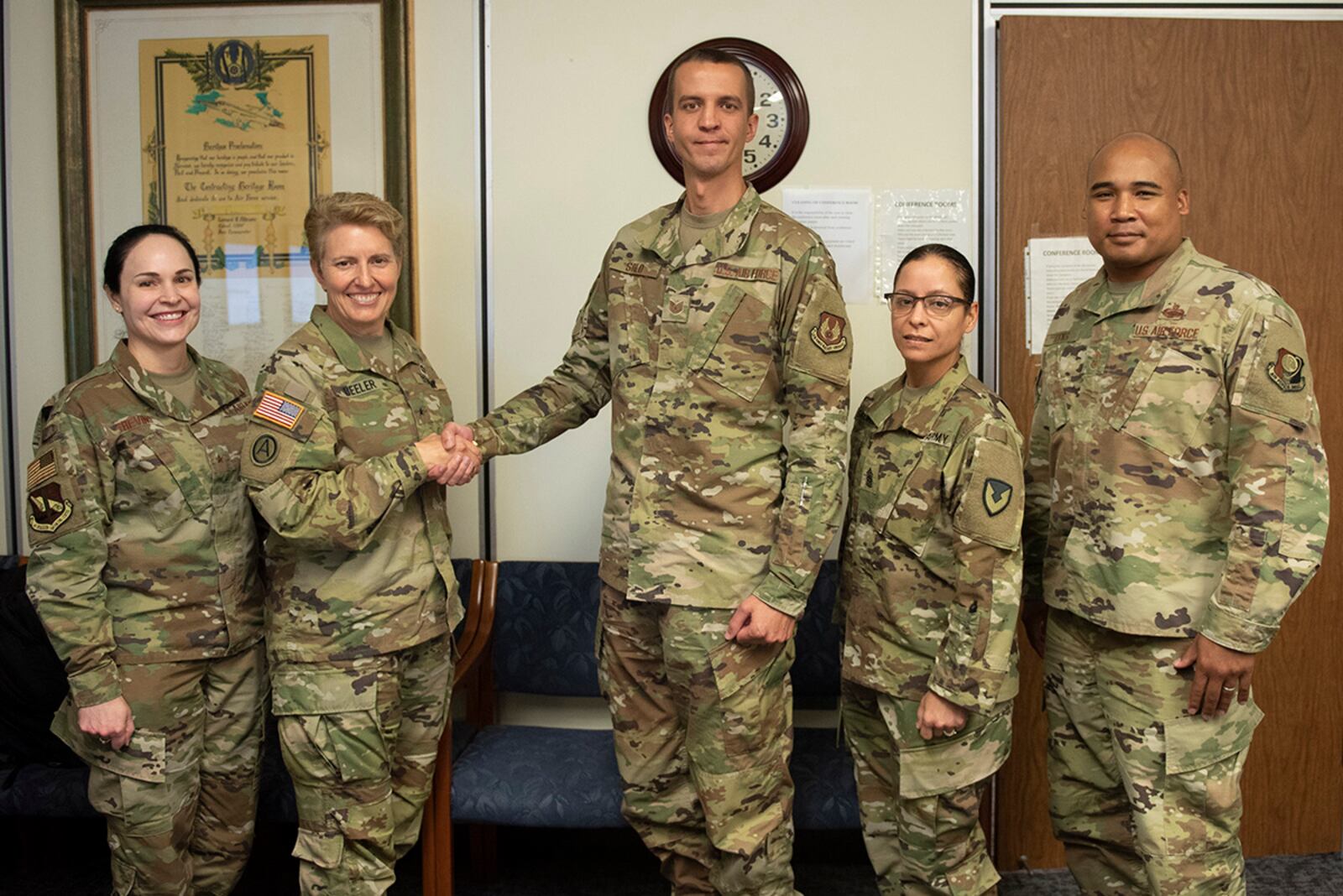 Army Brig. Gen. Christine Beeler (second from left), commander of Mission and Installation Contracting Command, presents a coin to Tech Sgt. Michael Solo, a contracting officer with the Air Force Life Cycle Management Center, for his work during the joint force contracting exercise June 24 at Wright-Patterson Air Force Base. U.S. AIR FORCE PHOTO/WESLEY FARNSWORTH