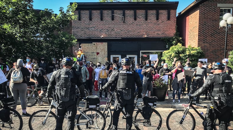 Police officers keep protesters from walking on Fifth Street on Sunday during protests.