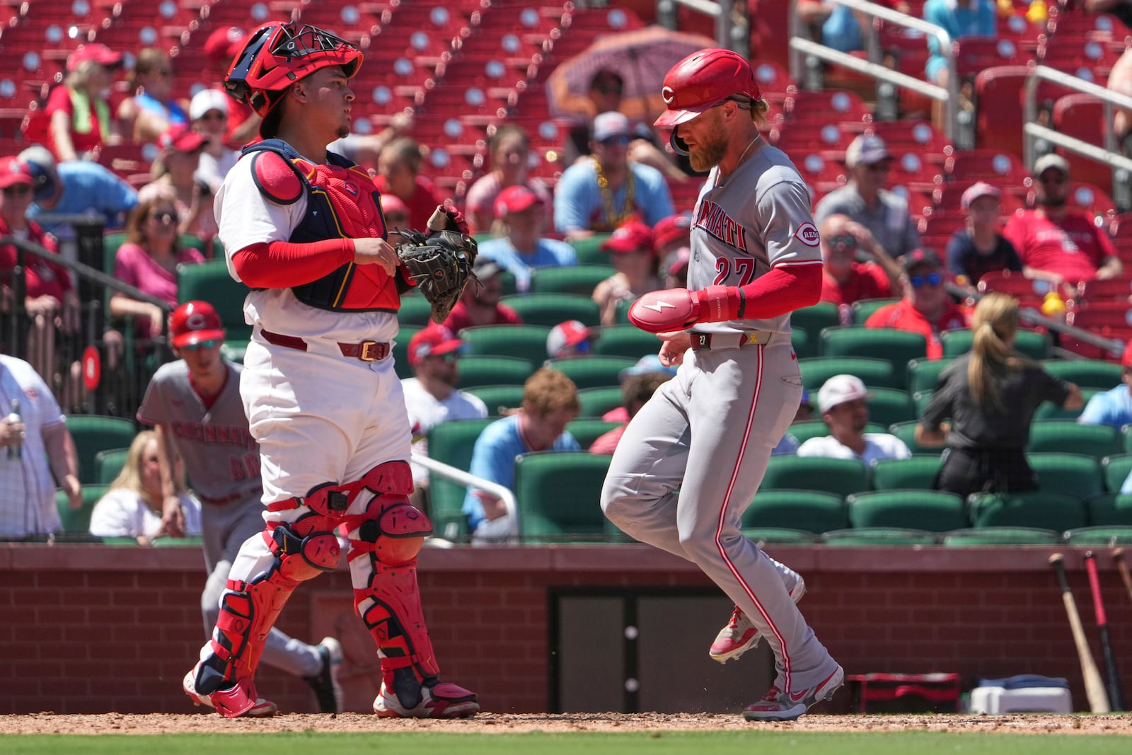 Cincinnati Reds' Jake Fraley, left, scores past St. Louis Cardinals catcher Yohel Pozo during the fifth inning of a baseball game Sunday, June 22, 2025, in St. Louis. (AP Photo/Jeff Roberson)