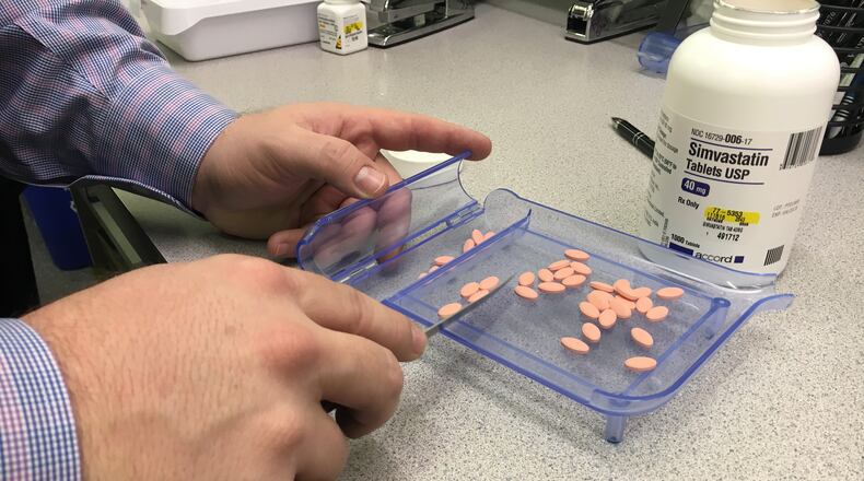 Pharmacist Kyle Fields counts pills at Waynesville Pharmacy, Dec. 2, 2016. The Dayton Daily News has been digging into the complex system behind how prescription drugs get priced. KATIE WEDELL/STAFF
