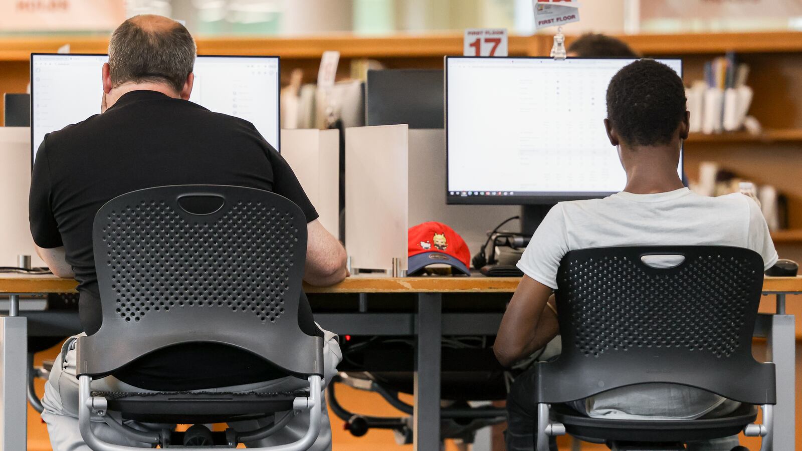 Two men use a computer at Dayton Metro Library's main branch on Wednesday, June 25. BRYANT BILLING / STAFF