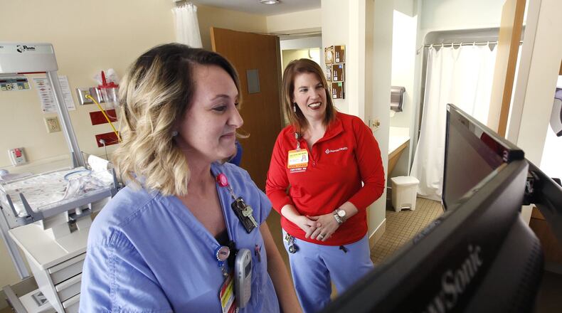 Emily Hayes, R.N., right, reviews patient records software with Adrienne Linville, R.N. at Miami Valley Hospital’s Berry Women’s Center. Demand for registered nurses is high and is reflected in the numbers of those leaving the profession. TY GREENLEES / STAFF