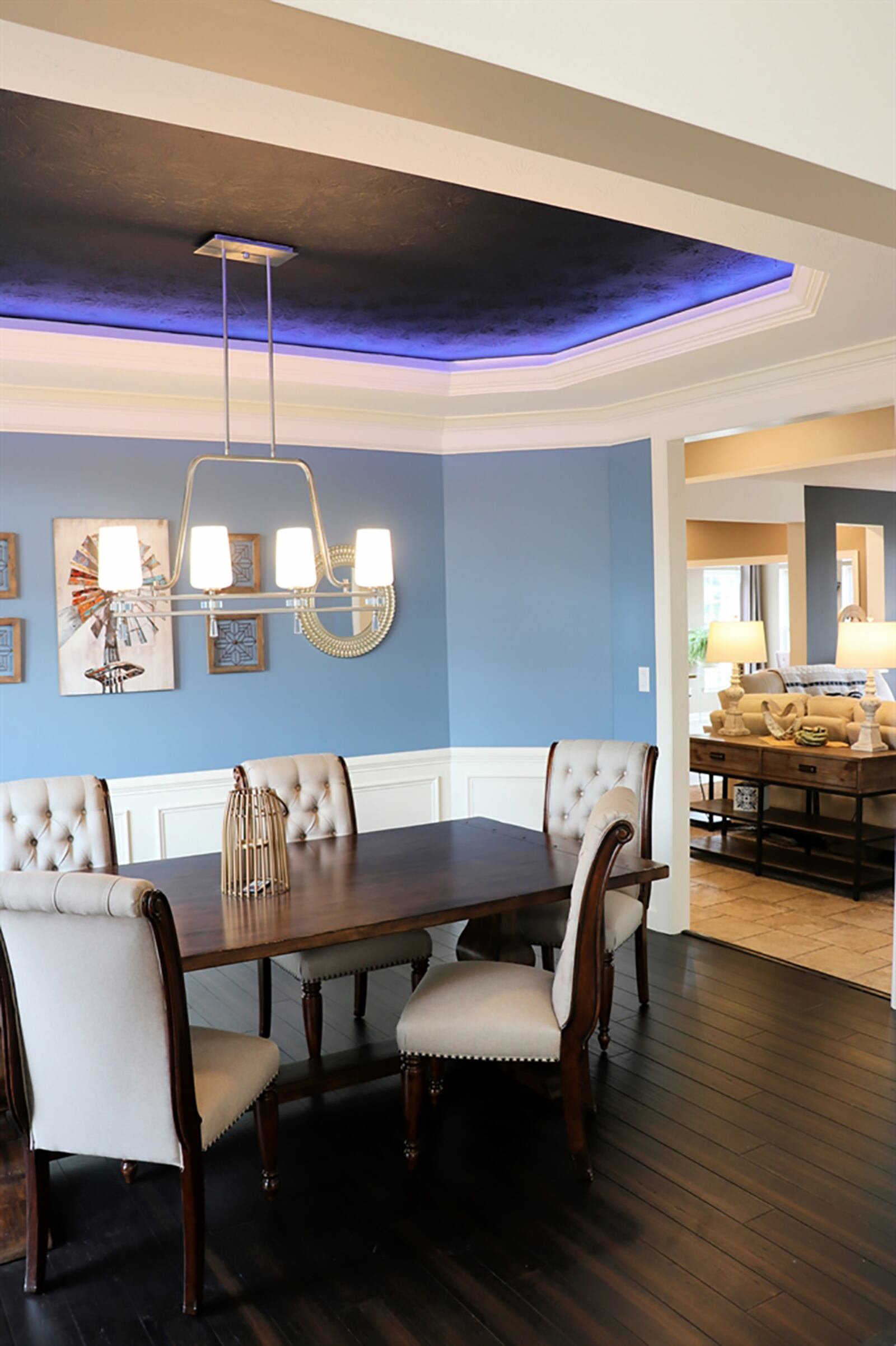 The formal dining room has wood flooring and a tray ceiling with accent lights and wainscoting. CONTRIBUTED PHOTO BY KATHY TYLER