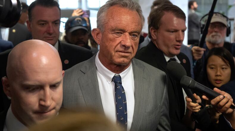 FILE - Robert Kennedy Jr., center, President-elect Donald Trump's pick to lead the Health and Human Services Department, walks between meetings with senators on Capitol Hill, Tuesday, Dec. 17, 2024, in Washington. (AP Photo/Mark Schiefelbein, File)