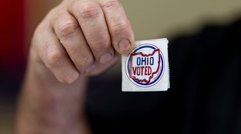 Voters grab "Ohio Voted" stickers after filling out ballots on Election Day at Chesapeake Elementary School on Tuesday, Nov. 7, 2023, in Chesapeake, Ohio. (Sholten Singer/The Herald-Dispatch via AP)