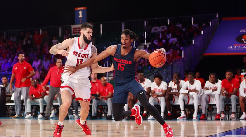 Dayton's DaRon Holmes II dribbles against N.C. State's Dusan Mahorcic in the first half on Thursday, Nov. 24, in the consolation round of the Battle 4 Atlantis at Imperial Arena at the Atlantis Paradise Island resort. David Jablonski/Staff