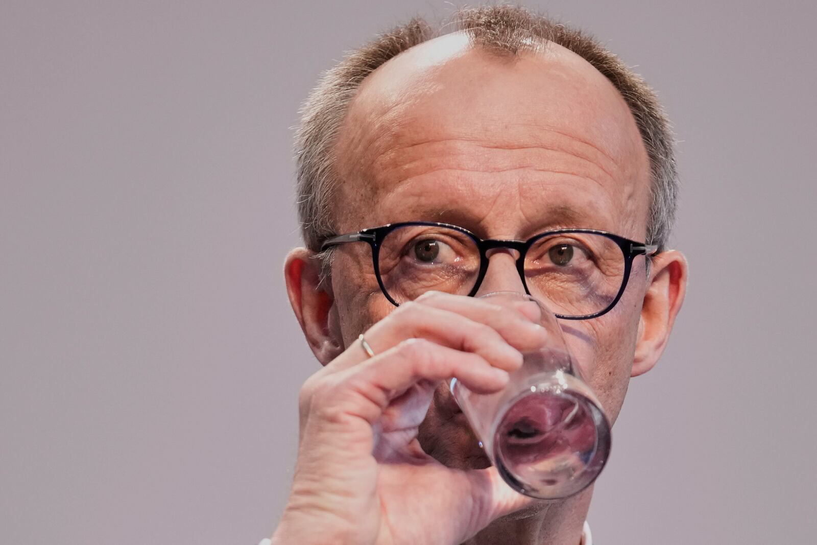 Friedrich Merz, Christian Democratic Union party chairman, drinks water during a press conference after reaching an agreement between their parties on a coalition for a new German government at a news conference in Berlin, Germany, Wednesday, April 9, 2025. (AP Photo/Ebrahim Noroozi)