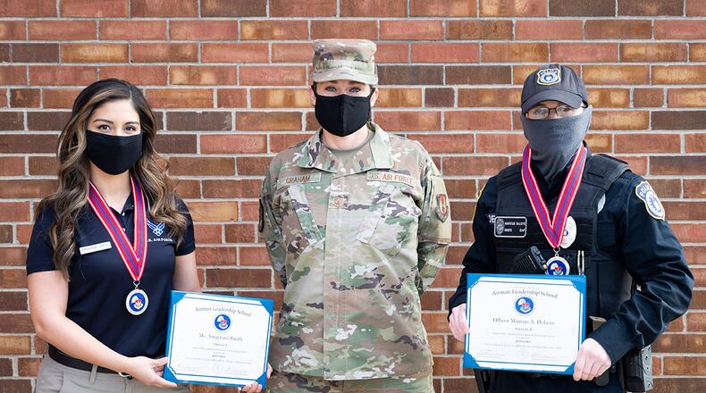 From left: Amayrani Smith, 88th Force Support Squadron recreation assistant; Master Sgt. Kelly Graham, Airman Leadership School commandant; and Marcus Deloye, 88th Security Forces Squadron officer, are pictured outside the Airman Leadership School building at Wright-Patterson Air Force Base on Dec. 8. Smith and Deloye became the first two civilians to graduate from ALS. U.S. AIR FORCE PHOTO/WESLEY FARNSWORTH