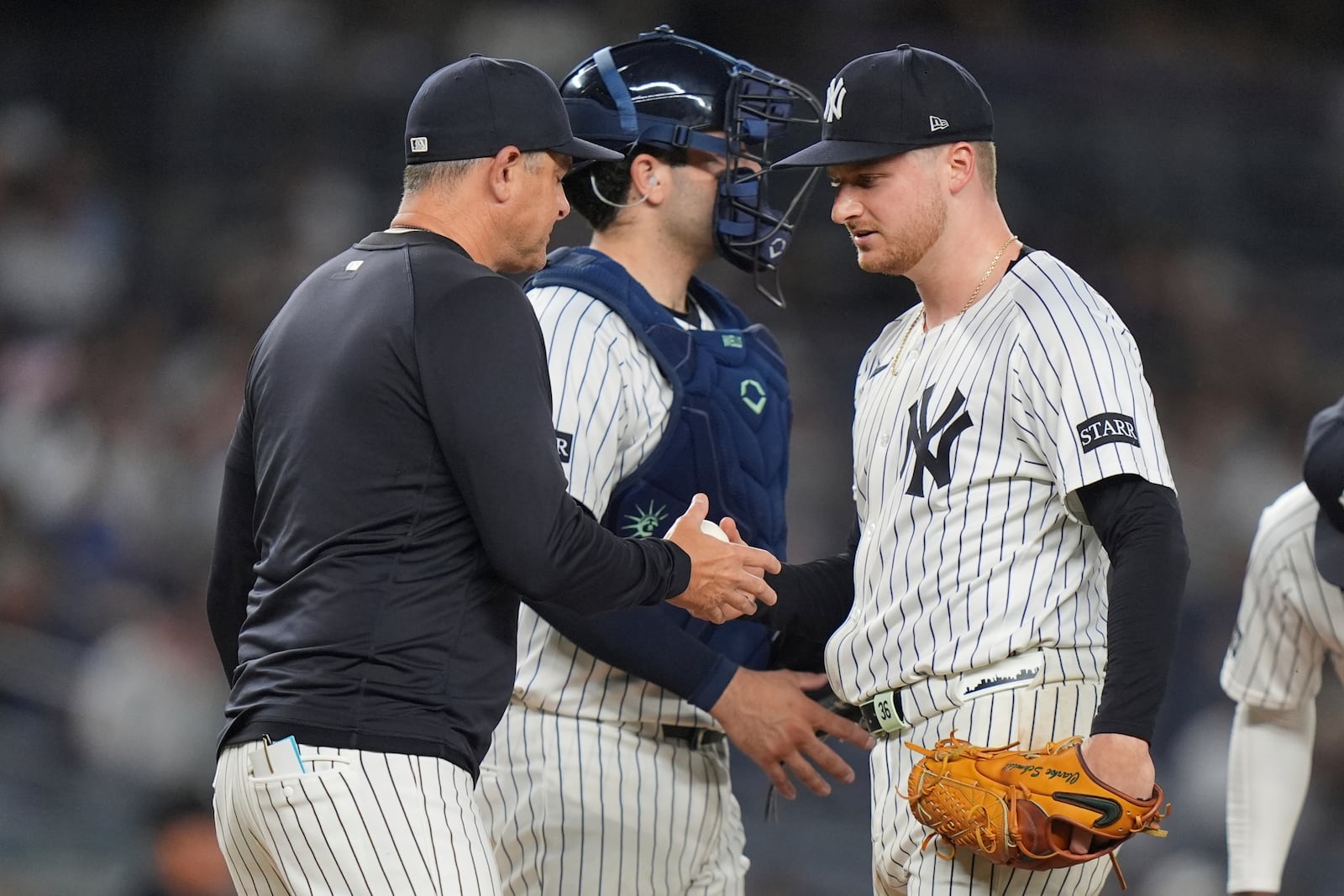 New York Yankees pitcher Clarke Schmidt hands the ball to manager Aaron Boone as he leaves during the sixth inning of a baseball game, Wednesday, June 4, 2025, in New York. (AP Photo/Frank Franklin II)