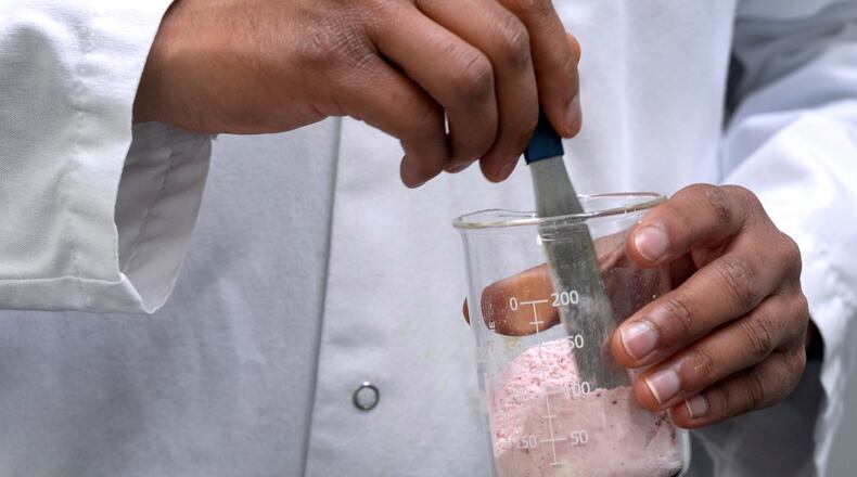 FILE - Applications Scientist Anuj Bag mixes coloring with flour at Sensient Technologies Corp., a color additive manufacturing company, April 2, 2025, in St. Louis. (AP Photo/Jeff Roberson, File)