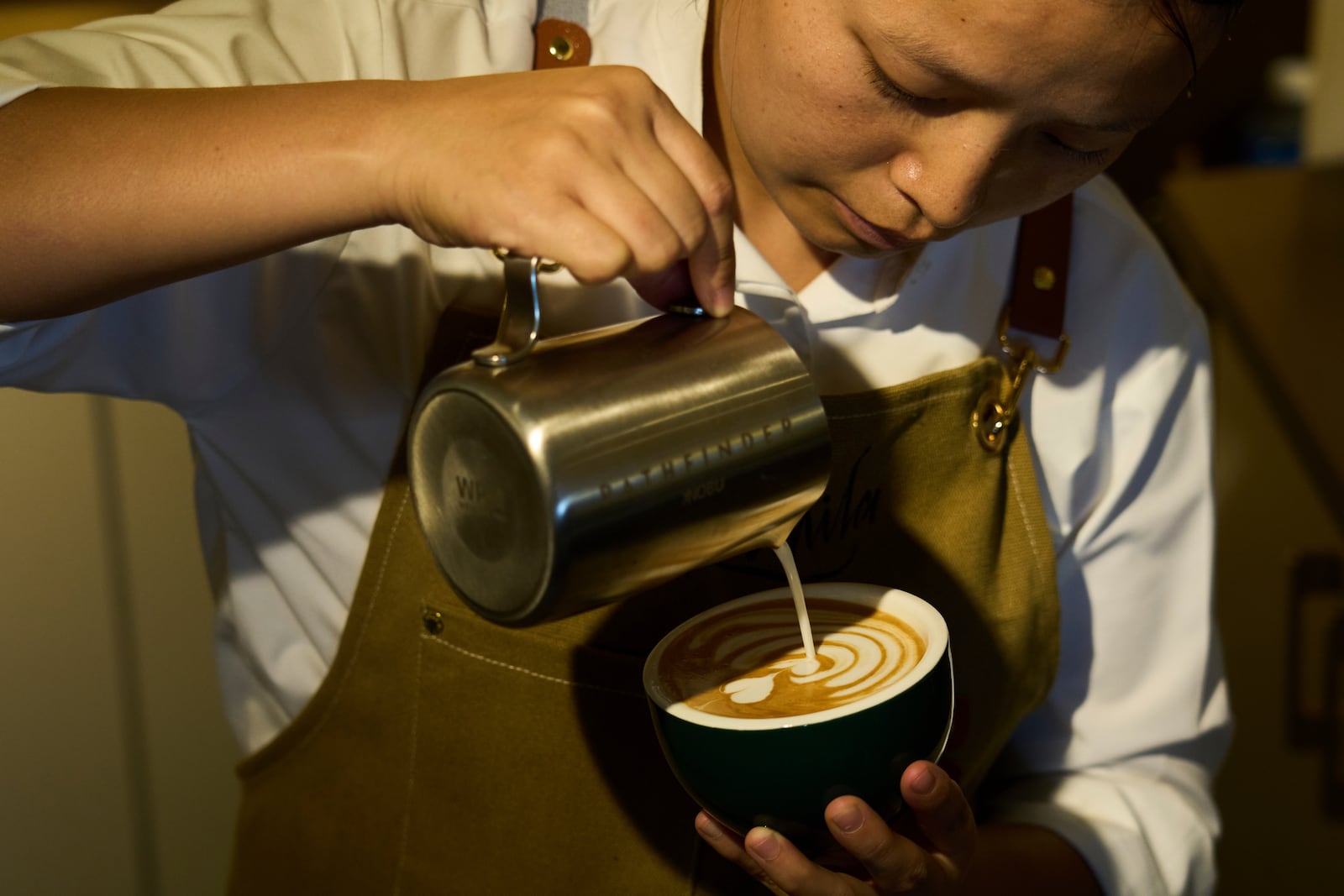 An employees pours coffee for a customer at Himalayan Java cafe at Boudhanath Stupa in Kathmandu, Nepal, Tuesday, June 10, 2025. (AP Photo/Niranjan Shrestha)