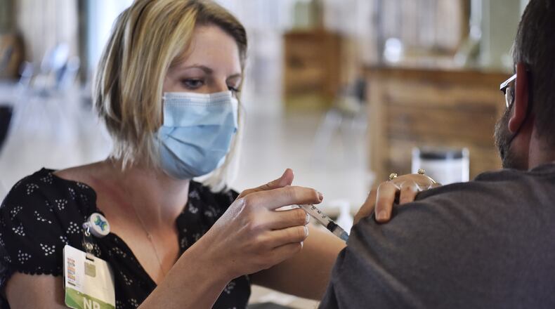 Kendra Chesnut, left, from Mercy Health, gives a vaccine to Matt Seiter. Mercy Health-Fairfield Hospital offered first-dose vaccinations at Jungle Jim's Oscar Event Center in Fairfield Tuesday, April 6, 2021, and will offer them from 9 a.m. to 2 p.m. Wednesday, April 7, 2021. It's estimated 1,200 people, 600 on Tuesday and 600 on Wednesday, will receive the first-shot of the novel coronavirus vaccine. NICK GRAHAM / STAFF