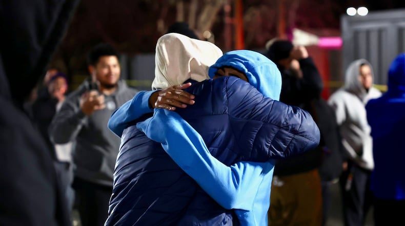 CORRECTS YEAR TO 2026 - People hug each other after a fatal shooting in a parking lot of The Church of Jesus Christ of Latter-day Saints in Salt Lake City on Wednesday, Jan. 7, 2026. (Laura Seitz/The Deseret News via AP)