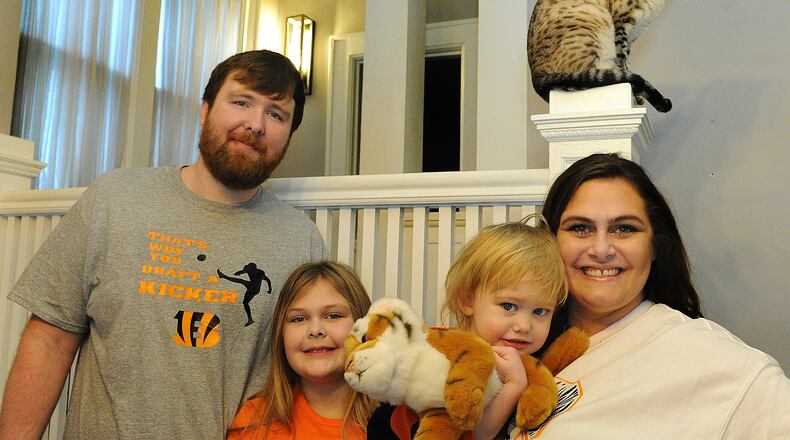 The Young family of Piqua: from left, Brandon, Lily, 9; Ivy, 2; and Melissa, are lifelong Bengal fans. MARSHALL GORBY/STAFF