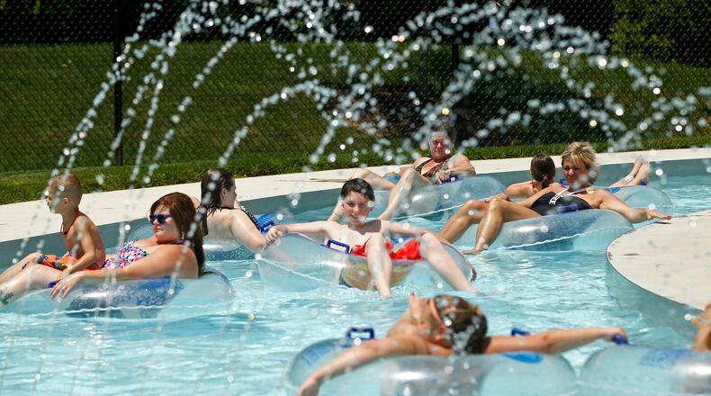 Swimmers at the Kroger Aquatics Center at The Heights float around the Lazy River on a warm Tuesday afternoon.  The parking lot of the water park was almost full by noon.   TY GREENLEES / STAFF