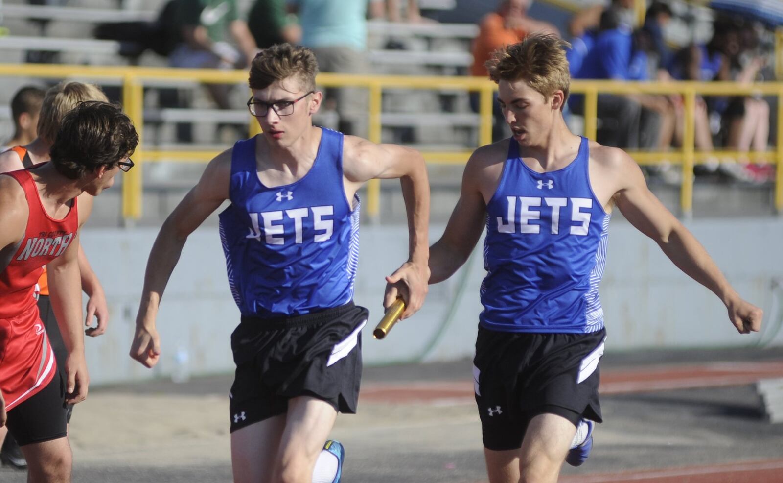 Franklin Monroe’s Kyle Ressler (right) hands off to teammate Zach Gilliland in a 4x200 relay heat during Tuesday’s Division III high school track and field district meet at Dayton’s Welcome Stadium. MARC PENDLETON / STAFF