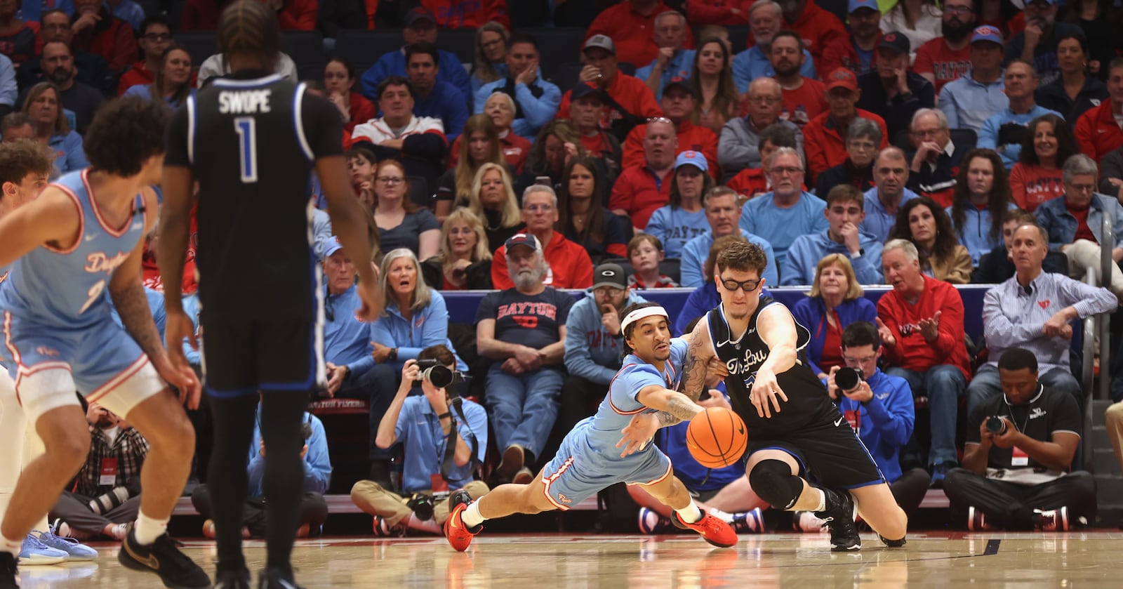 Dayton's Javon Bennett dives for a loose ball against Robbie Avila, of Saint Louis, on Tuesday, March 4, 2025, at UD Arena. David Jablonski/Staff