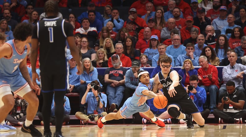 Dayton's Javon Bennett dives for a loose ball against Robbie Avila, of Saint Louis, on Tuesday, March 4, 2025, at UD Arena. David Jablonski/Staff