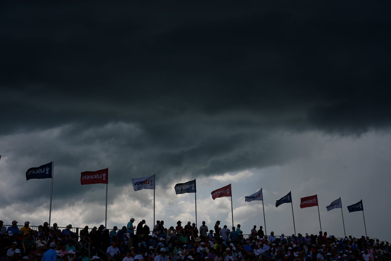 Storms clouds hang over the grandstand overlooking the eighth green during the third round of the U.S. Open golf tournament at Oakmont Country Club Saturday, June 14, 2025, in Oakmont, Pa. (AP Photo/Carolyn Kaster)