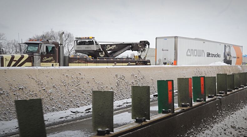 Crews clean up after a semi took down a light pole and hit the wall on I-75 southbound south of US 35 Thursday morning, Feb. 11, 2021.