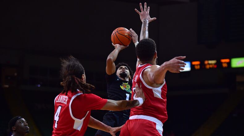 Wright State's Trey Calvin puts up a shot between two Western Kentucky defenders during Tuesday night's game at the Nutter Center. Wright State Athletics photo