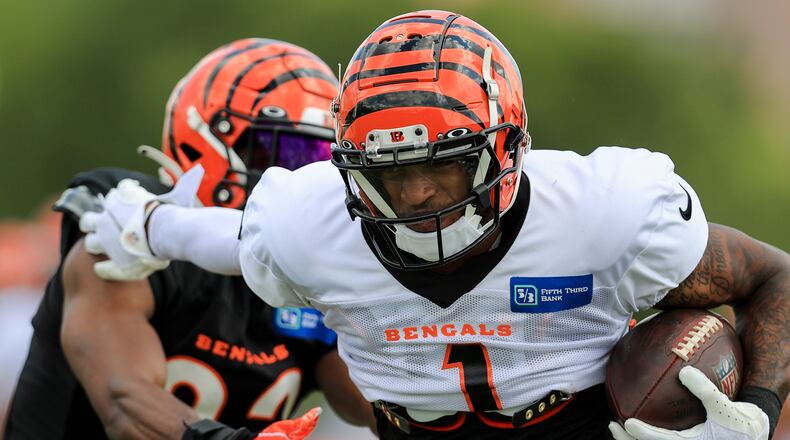 Cincinnati Bengals' Ja'Marr Chase (1) makes a catch against Chidobe Awuzie in a drill during an NFL football practice in Cincinnati, Tuesday, Aug. 3, 2021. (AP Photo/Aaron Doster)