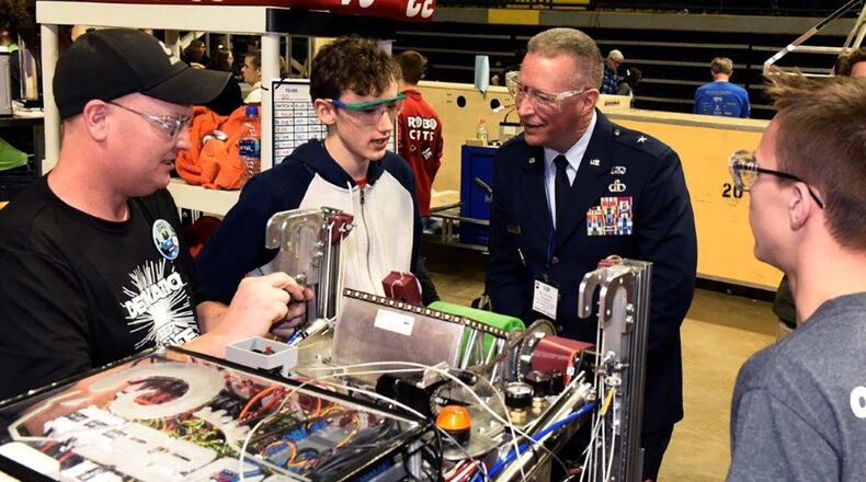 Brig. Gen. Brian Bruckbauer, Air Force Security Assistance and Cooperation Directorate director, listens to Ross High School team members as they prepare to compete in the in the Miami Valley FIRST Robotics Regional Competition at the Wright State University Nutter Center Feb. 28. (U.S. Air Force photo/Ty Greenlees)