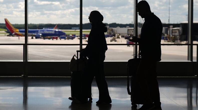 Travelers walk through the Baltimore/Washington International Thurgood Marshall Airport, Thursday, Oct. 2, 2025, in Baltimore. (AP Photo/Stephanie Scarbrough)
