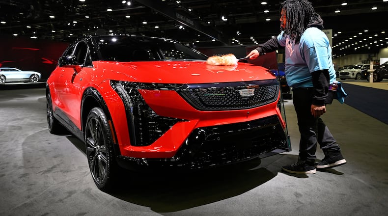 A worker dusts on a 2026 Cadillac Optiq Premium Sport vehicle at the Detroit Auto Show, Wednesday, Jan. 14, 2026, in Detroit. (AP Photo/Jose Juarez)