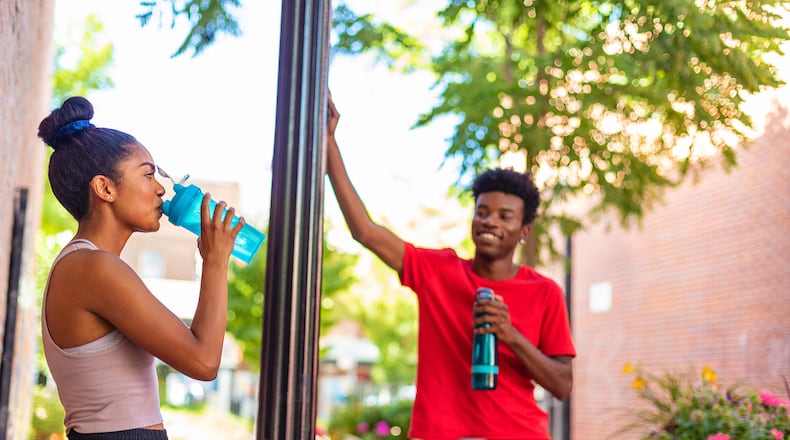 Couple staying hydrated while working out. ISTOCK