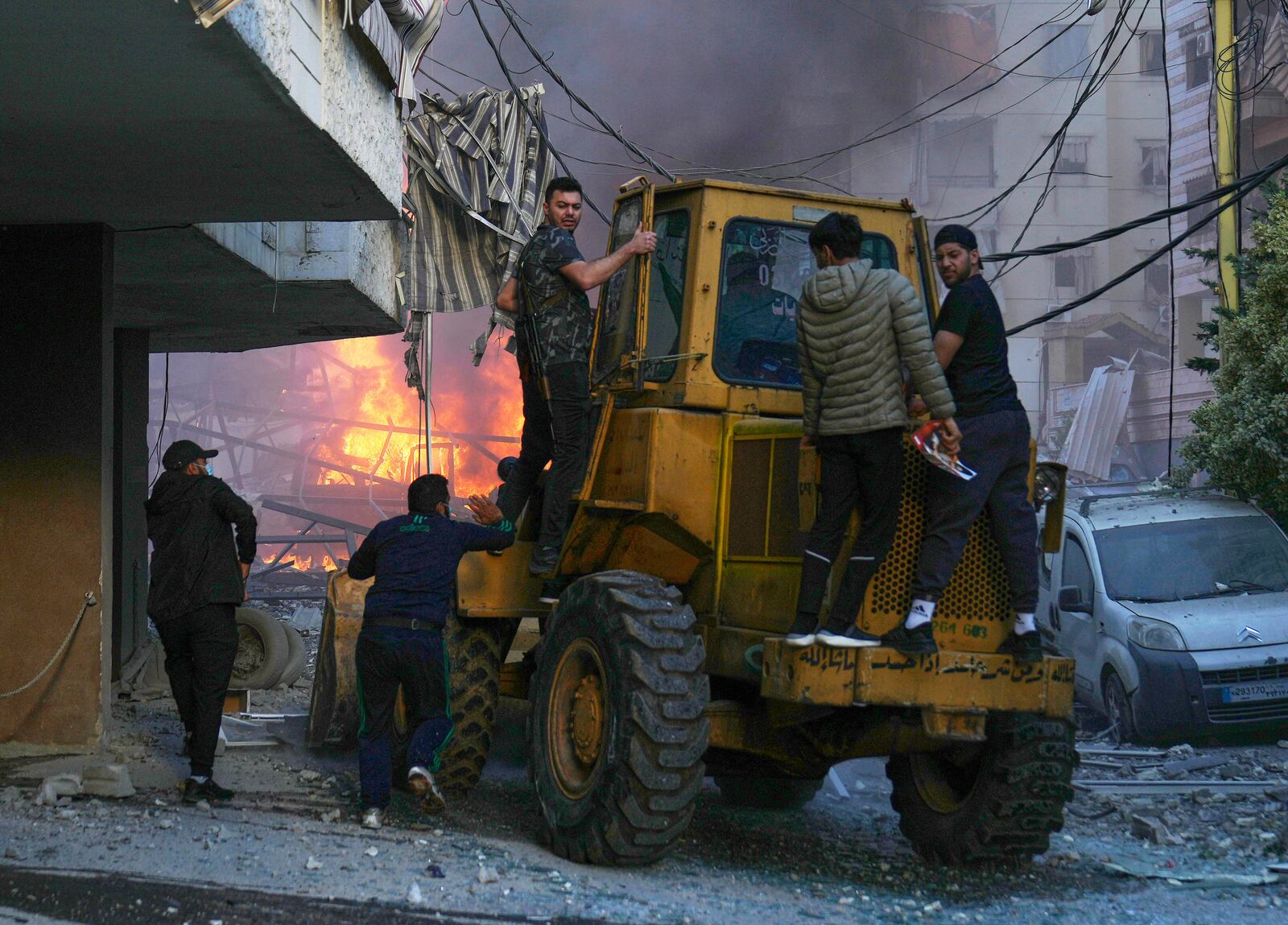 A bulldozer arrive to remove debris as flames rise from a metal tent that was hit by an Israeli airstrike on Dahiyeh in the southern suburb of Beirut, Lebanon, Sunday, April 27, 2025. (AP Photo/Hussein Malla)