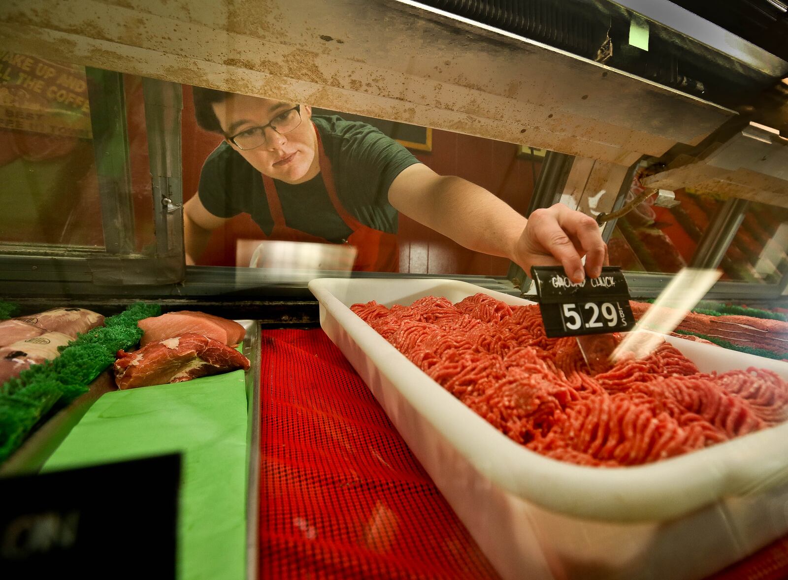 Nick Waker, assistant butcher at Zinks Meat Market in Centerville, sets up a display of ground chuck just before Memorial Day five weeks ago. JIM WITMER/STAFF