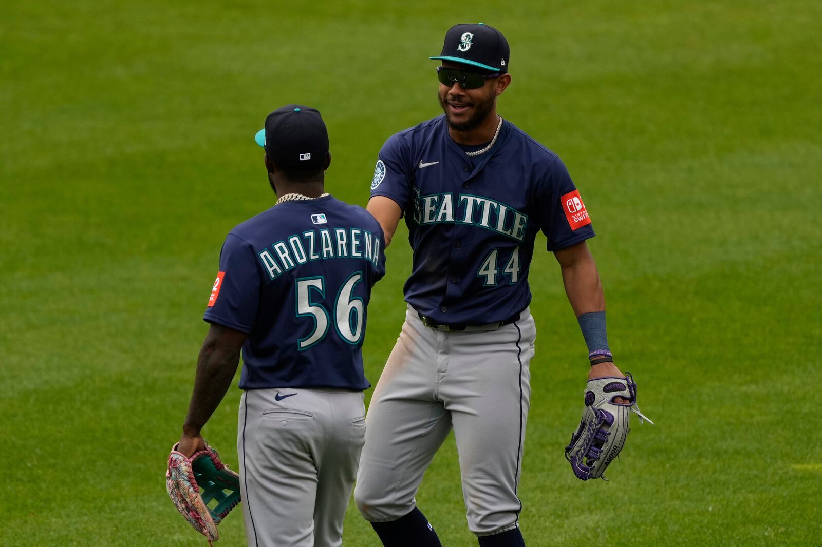 Seattle Mariners' Randy Arozarena (56) and Julio Rodríguez (44) celebrate after winning a baseball game against the Cincinnati Reds, Thursday, April 17, 2025, in Cincinnati. (AP Photo/Carolyn Kaster)