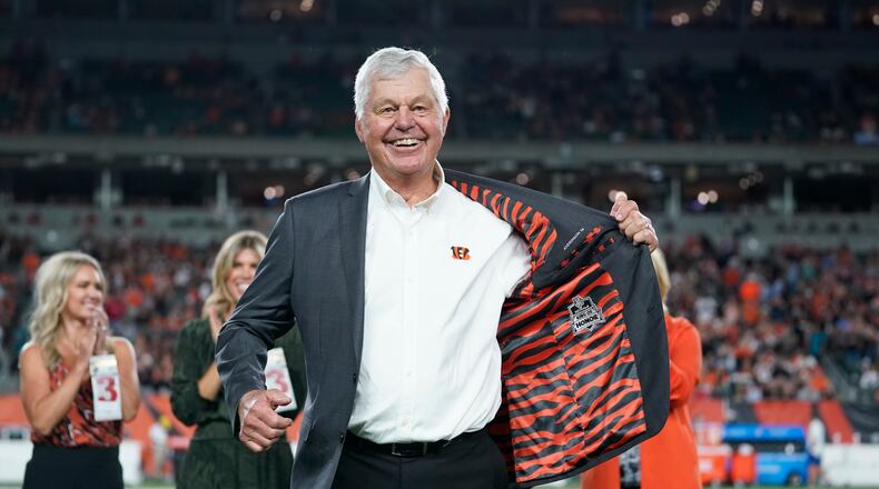 Former Cincinnati Bengals' Ken Anderson holds open his jacket during a "Ring of Honor" ceremony during an NFL football game between the Cincinnati Bengals and the Jacksonville Jaguars, Thursday, Sept. 30, 2021, in Cincinnati. (AP Photo/Michael Conroy)