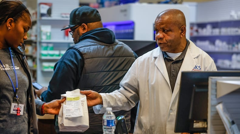 Ziks Family Pharmacist, Nnodum Iheme, right, works with pharmacy technician, Joy Duaka at the pharmacy on East Third St. Wednesday November 30, 2022. Starting in January 2025, Medicare Part D enrollees will have their out-of-pocket spending for prescription medication capped at $2,000 a year. JIM NOELKER/STAFF FILE