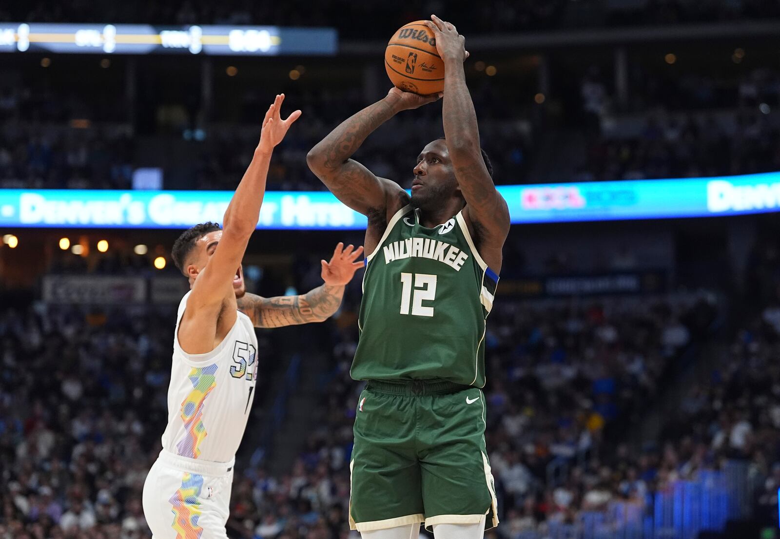 Milwaukee Bucks forward Taurean Prince, right, goes up for a 3-point basket as Denver Nuggets forward Michael Porter Jr. defends in the first half of an NBA basketball game Wednesday, March 26, 2025, in Denver. (AP Photo/David Zalubowski)