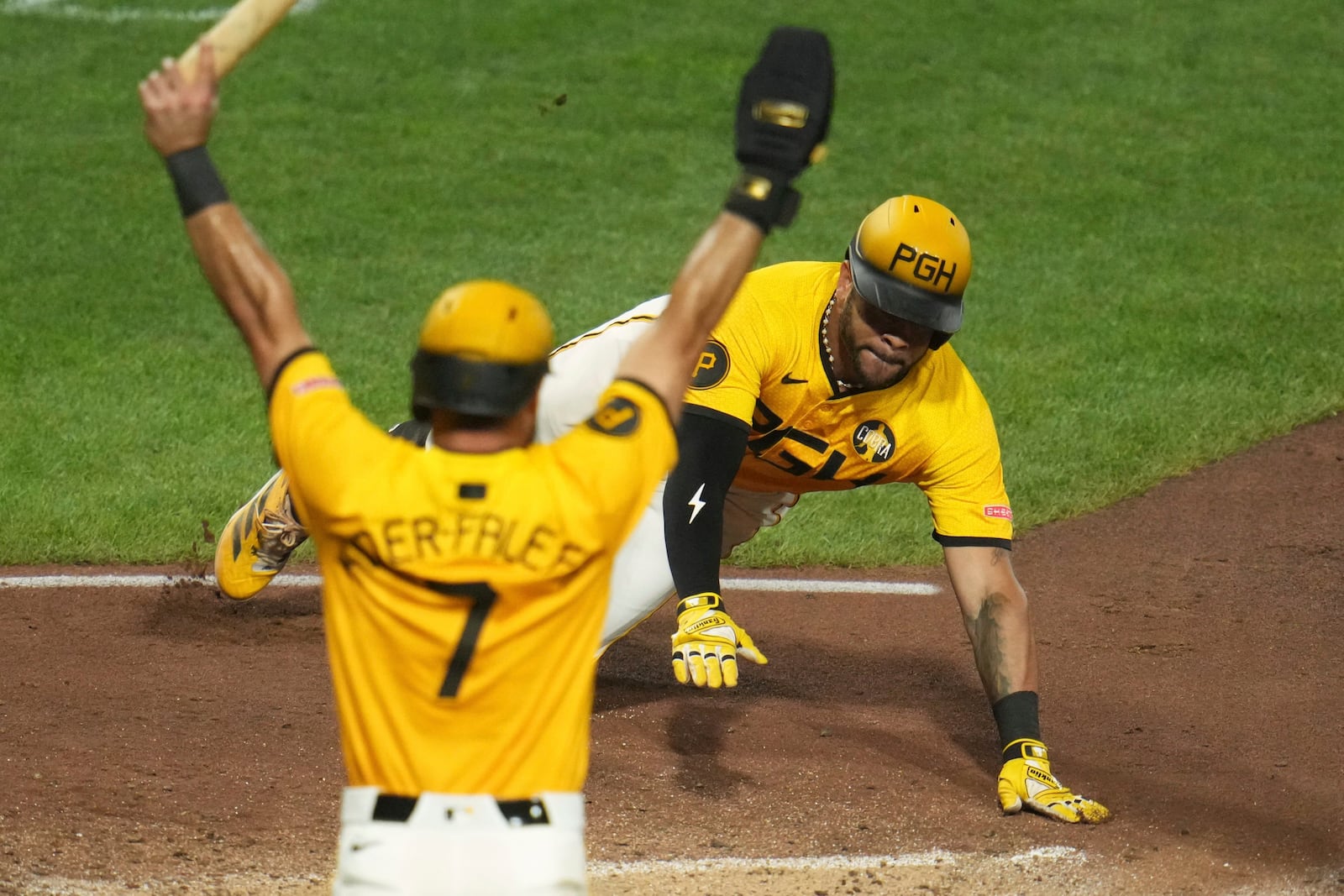 Pittsburgh Pirates' Tommy Pham, right, slides safely home with the second run driven in on a triple by Bryan Reynolds off Cincinnati Reds pitcher Tony Santillan during the eighth inning of a baseball game in Pittsburgh, Friday, Aug. 8, 2025. (AP Photo/Gene J. Puskar)