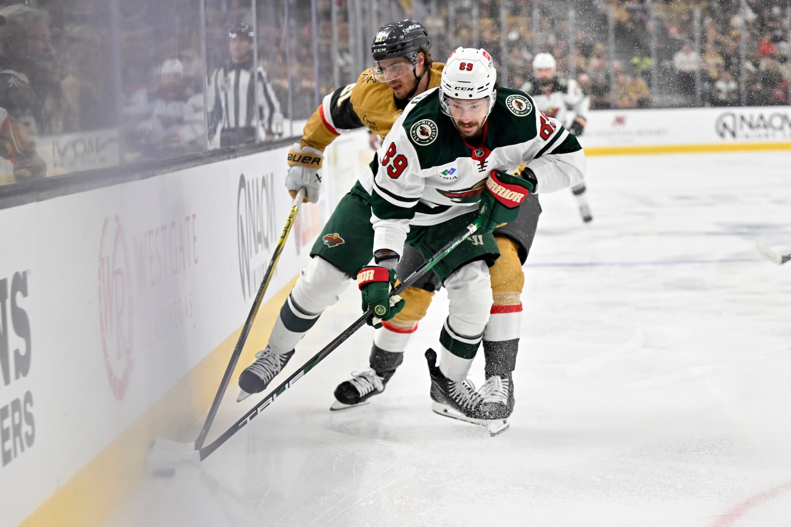 FILE - Vegas Golden Knights center Brett Howden (21) and Minnesota Wild center Frederick Gaudreau (89) battle for the puck during the first period of Game 5 of a first-round NHL hockey playoff series on April 29, 2025, in Las Vegas. (AP Photo/David Becker, File)